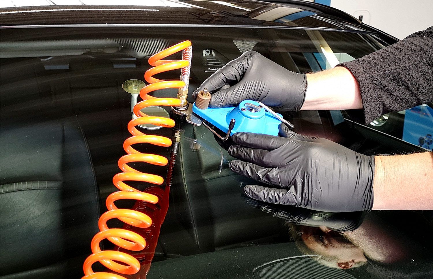 Windschutzscheiben-Reparatur mit Injektionswerkzeug an einem Fahrzeug